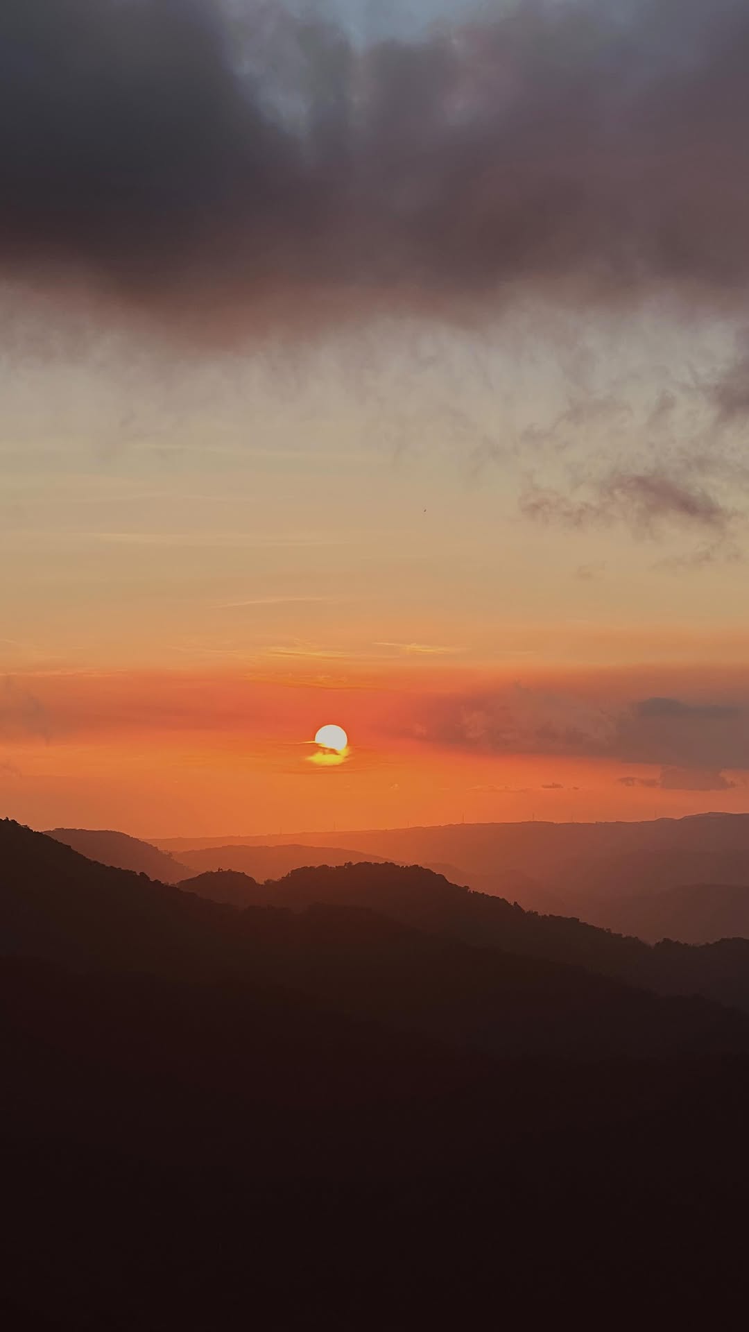 Mountain sunset viewed from Real, Quezon — layered ridgelines in orange and gold